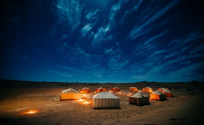 white and brown tent on brown field under blue sky during night time