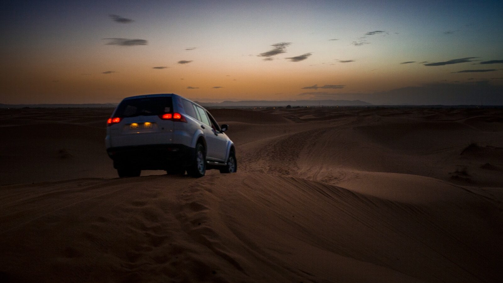 white SUV on desert during daytime